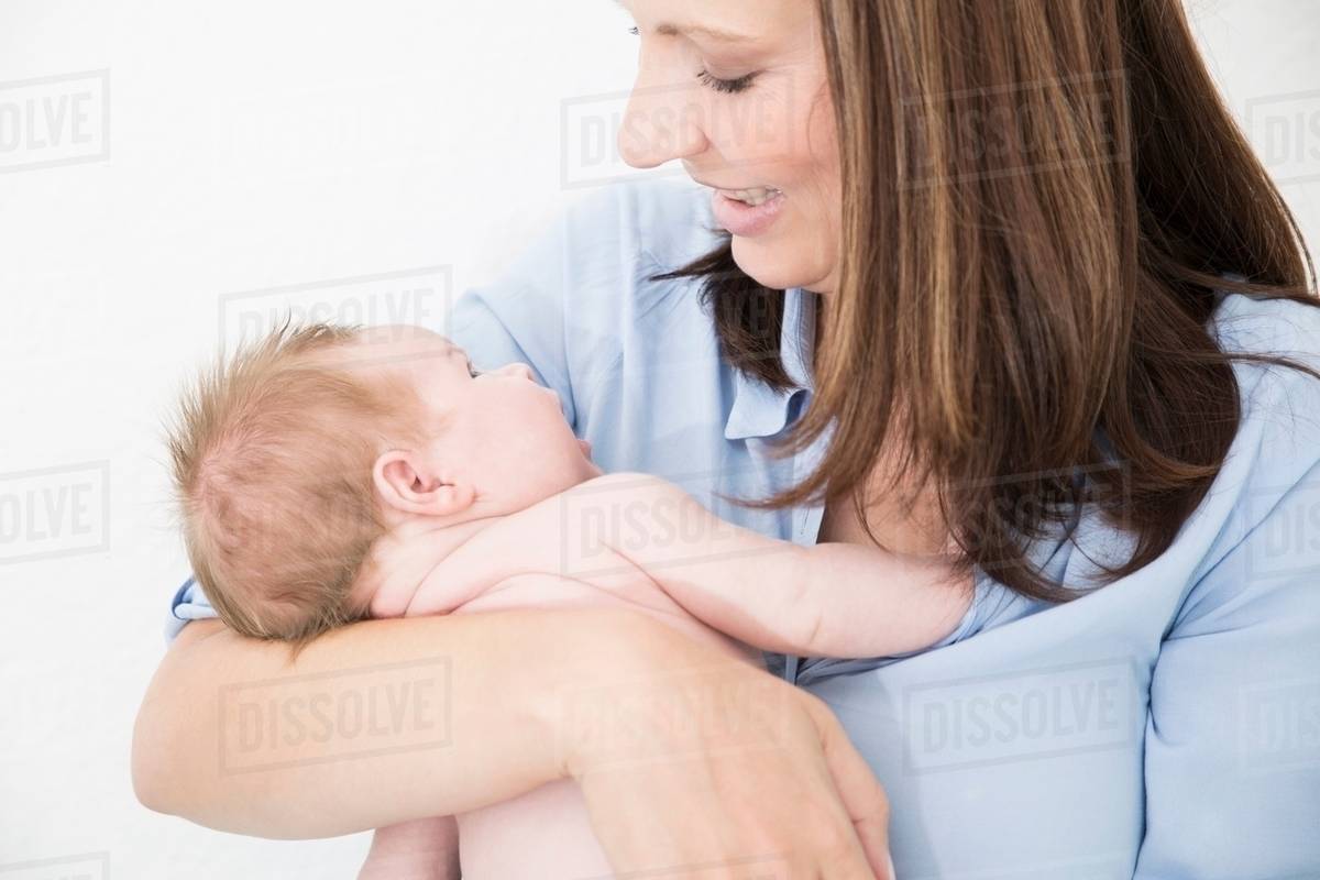 Mother cradling baby in arms Stock Photo Dissolve