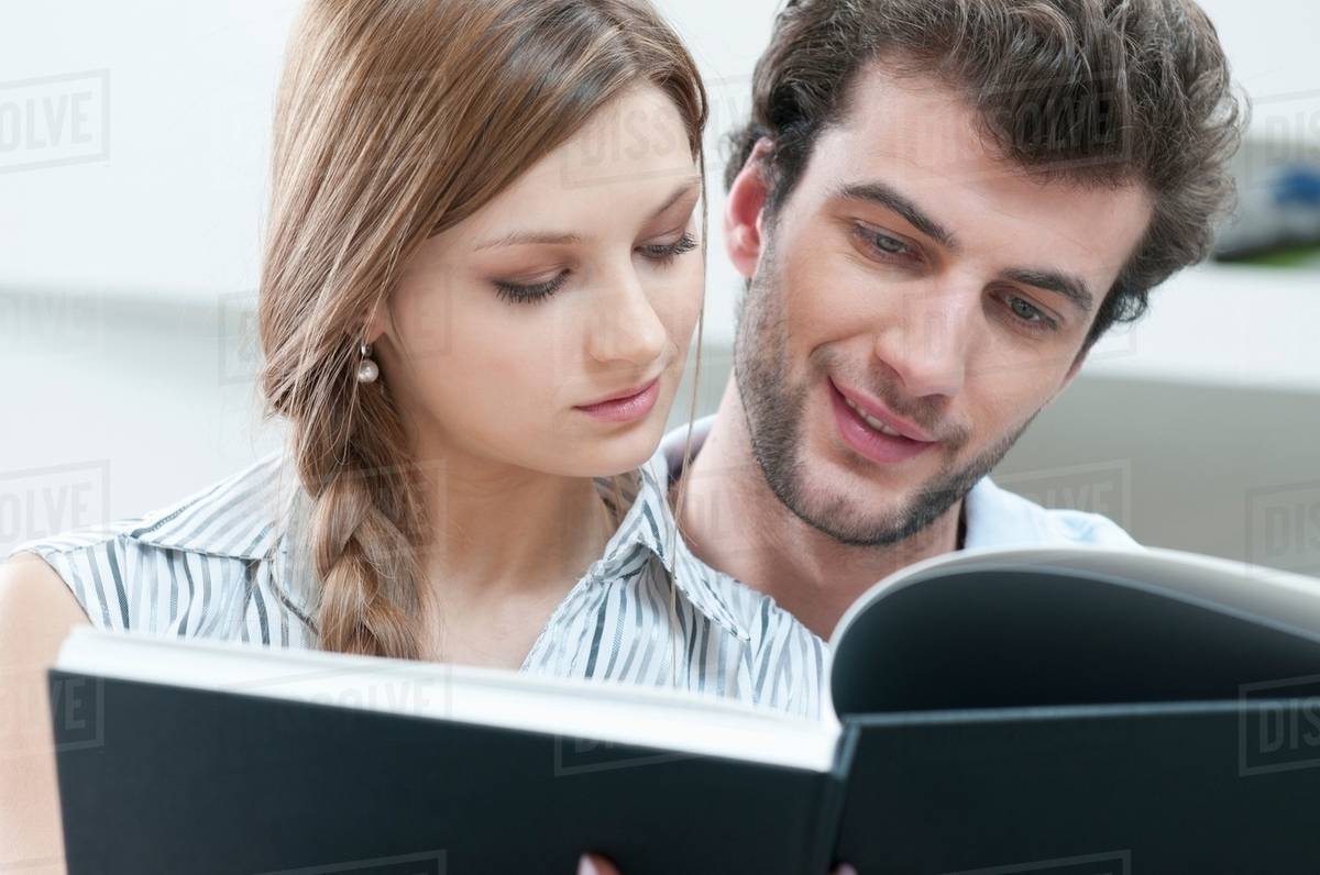 Young couple reading book together Stock Photo Dissolve