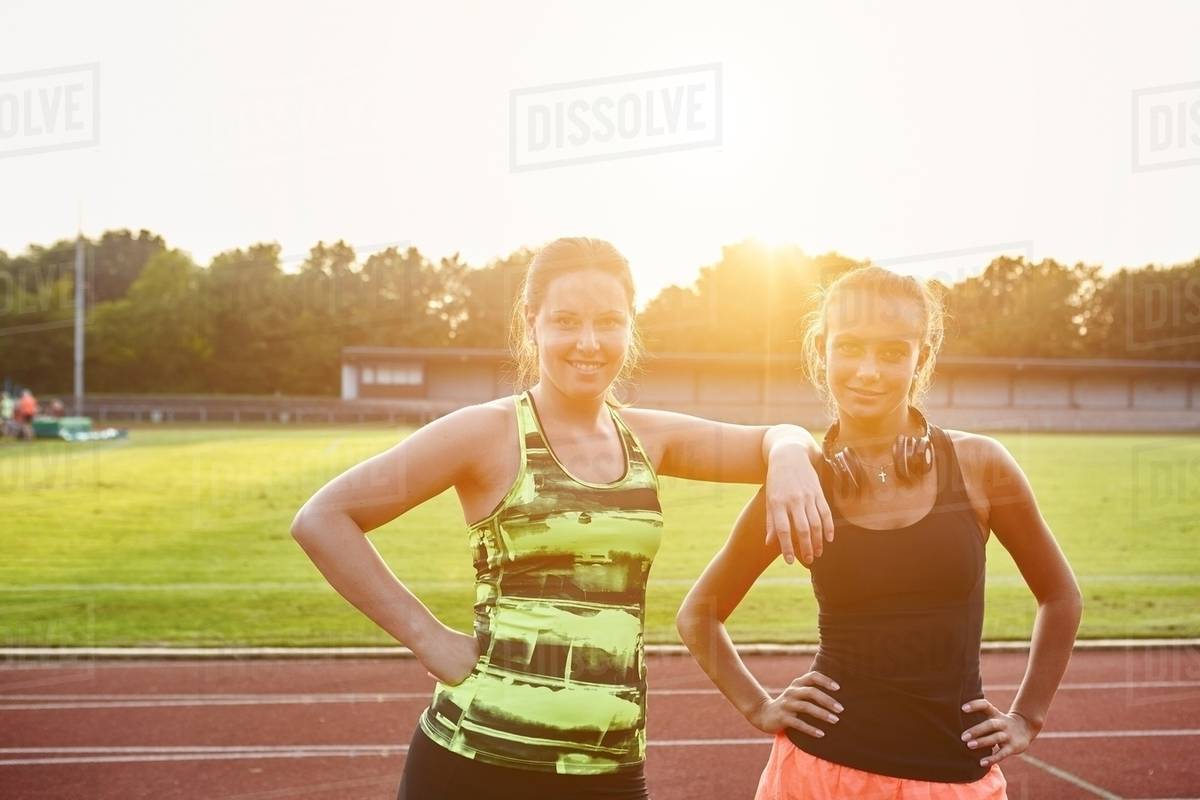 Portrait of two young female runners on race track Stock Photo Dissolve