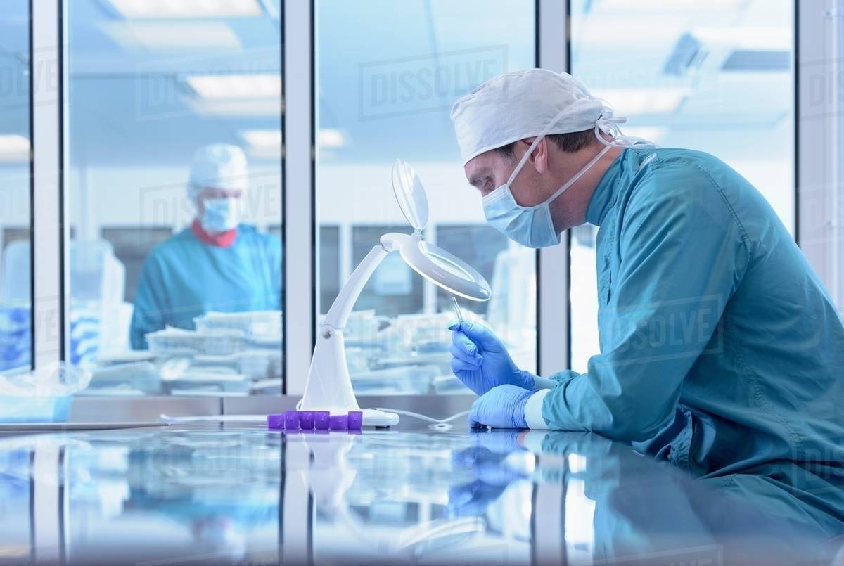 Workers inspecting surgical instruments in clean room of surgical