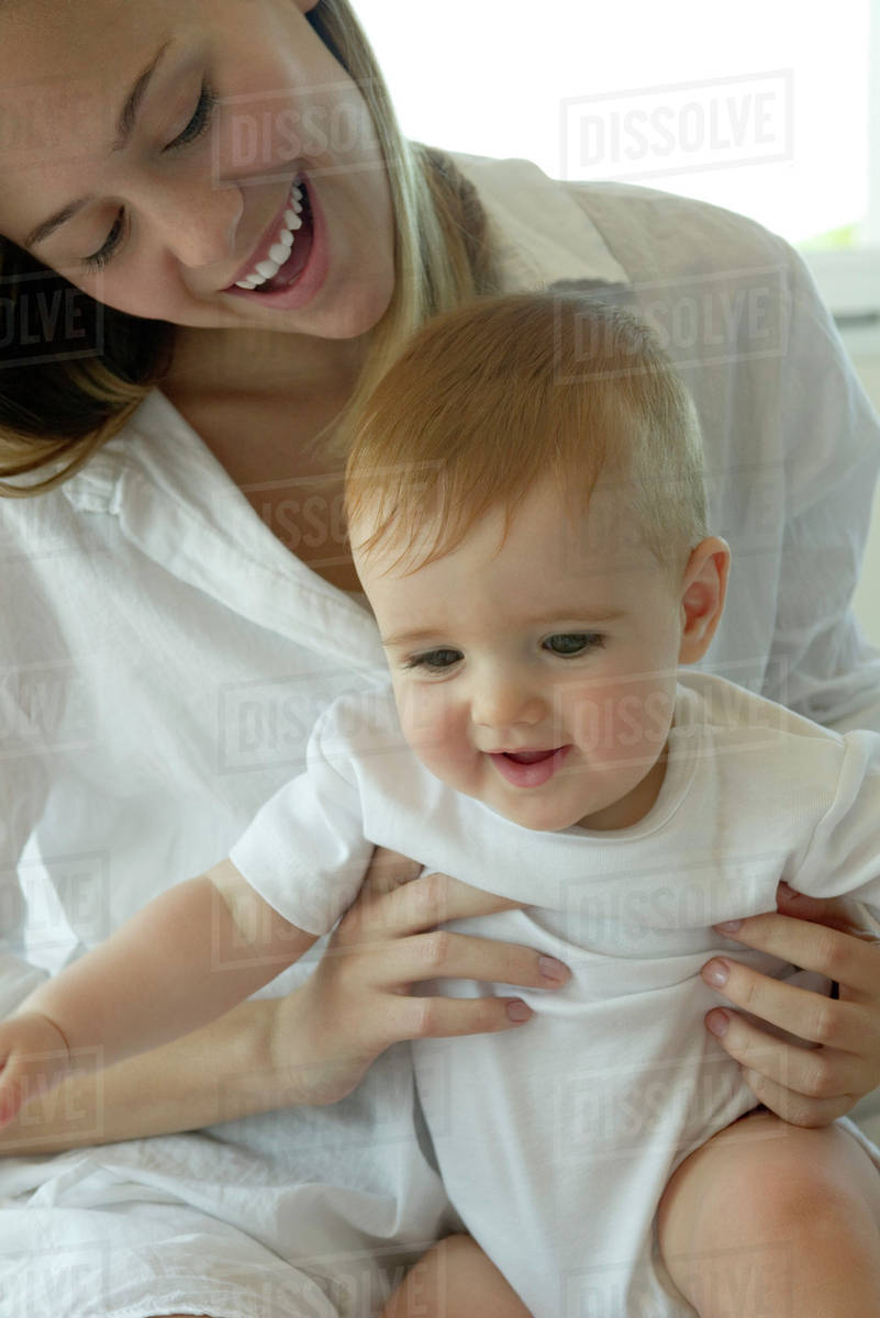 Mother holding baby on lap Stock Photo Dissolve