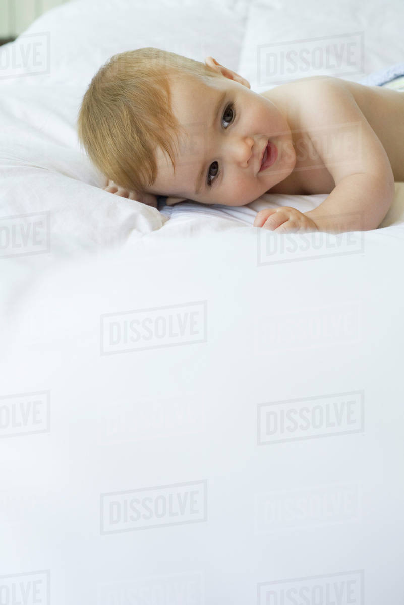 Baby lying on bed Stock Photo Dissolve