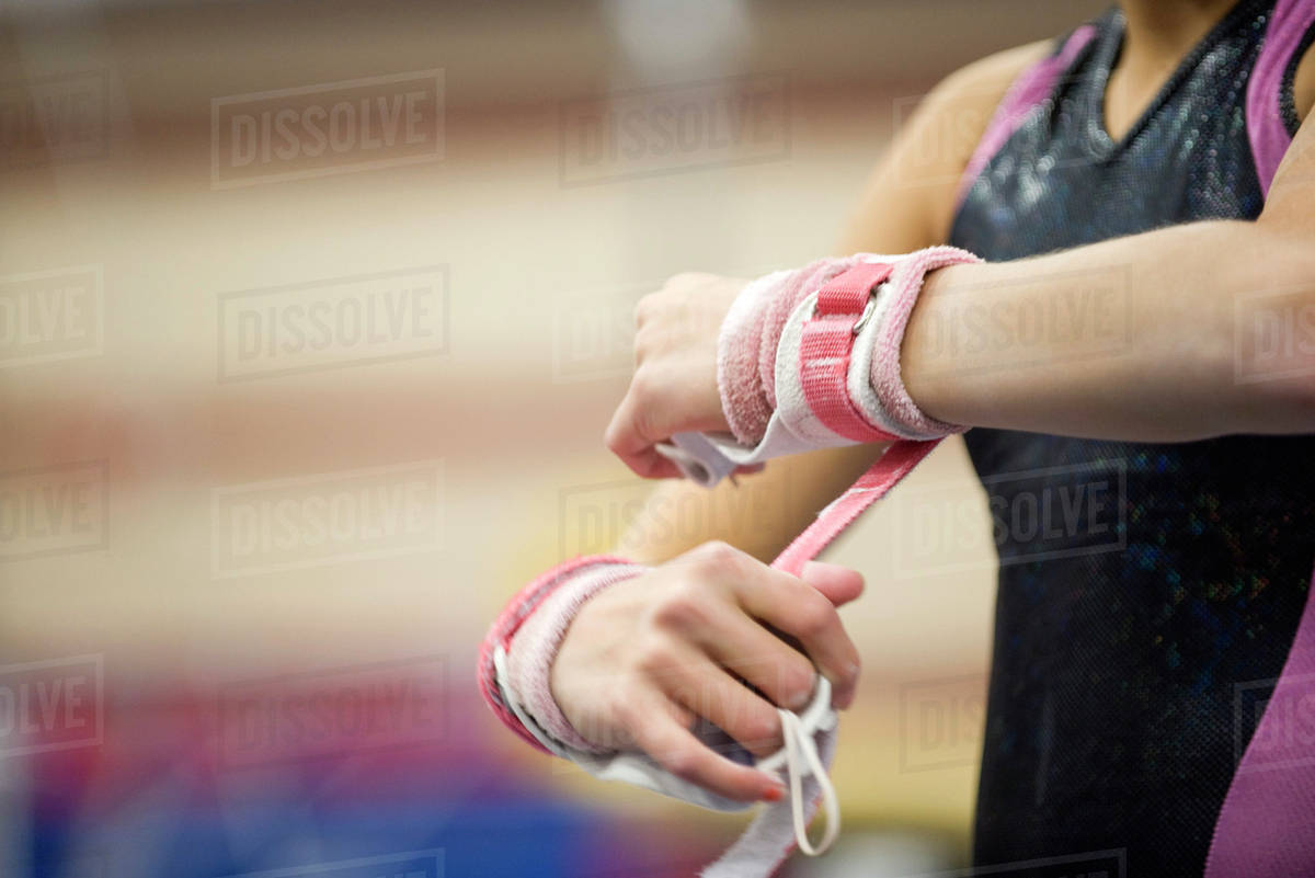 Female gymnast wrapping wrists in preparation, cropped Stock Photo