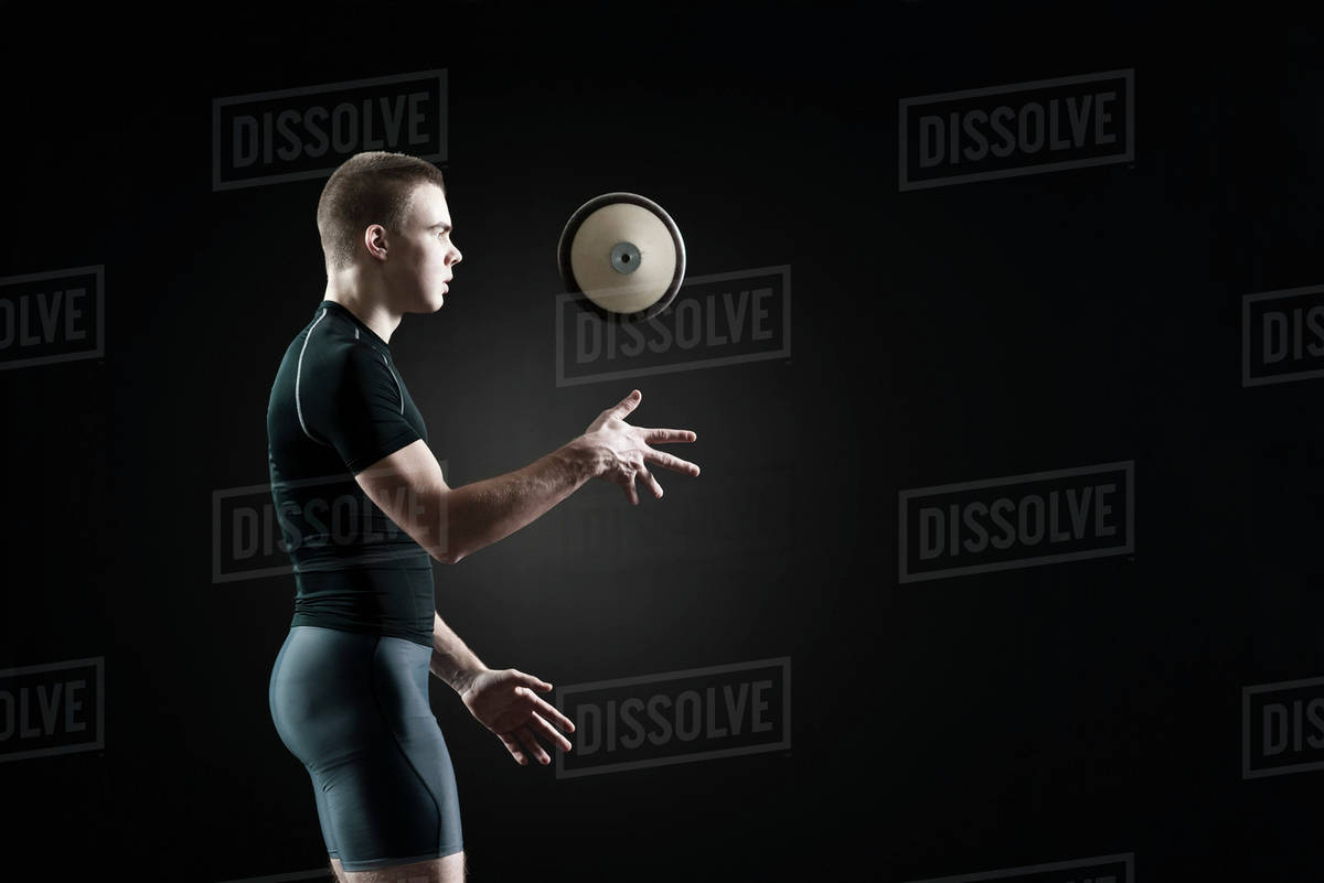 Male athlete throwing discus in air Stock Photo Dissolve