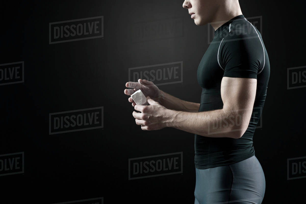 Male athlete applying chalk to hands Stock Photo Dissolve