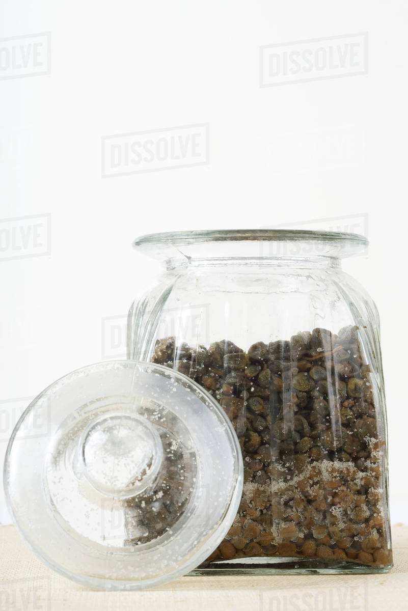 Capers and salt in jar, closeup Stock Photo Dissolve