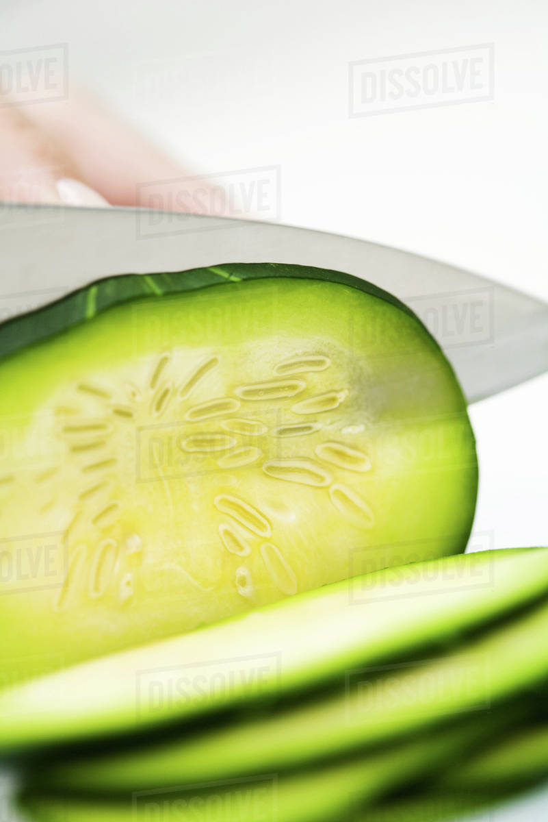 Knife cutting summer squash (zapallito redondo), extreme closeup