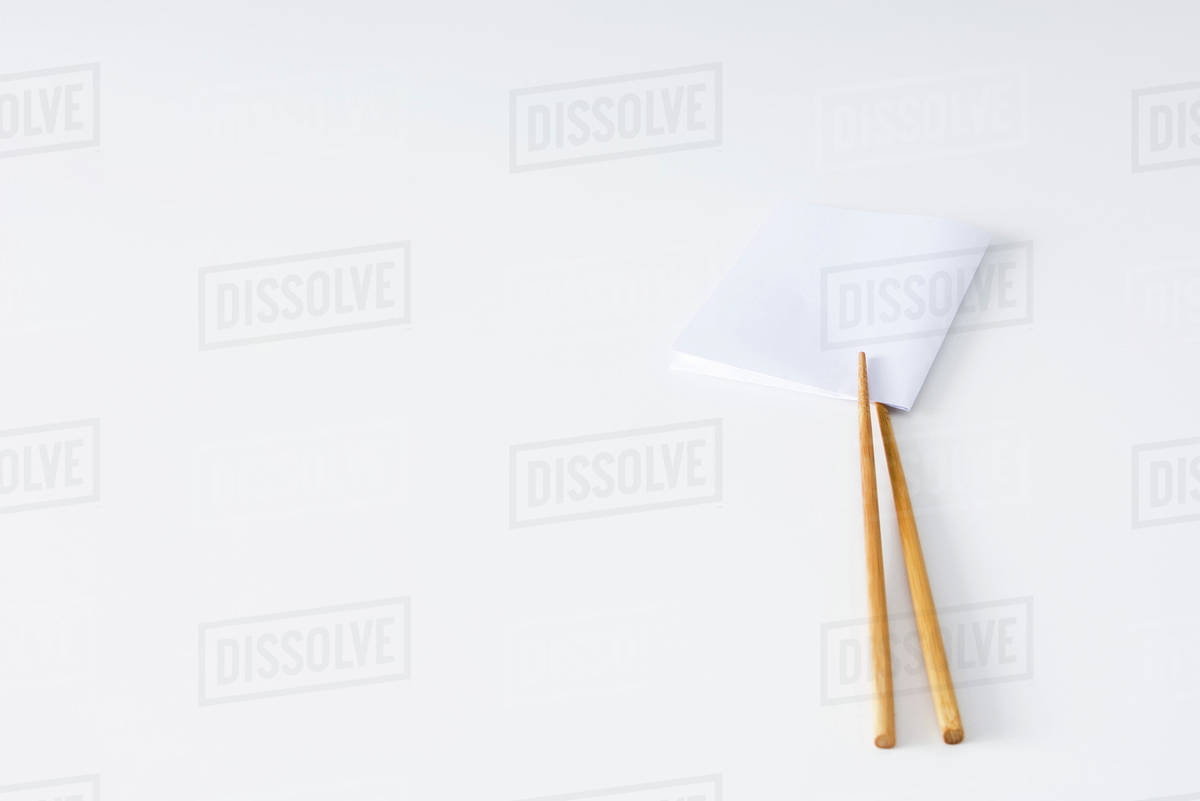 Chopsticks holding folded napkin, closeup Stock Photo Dissolve