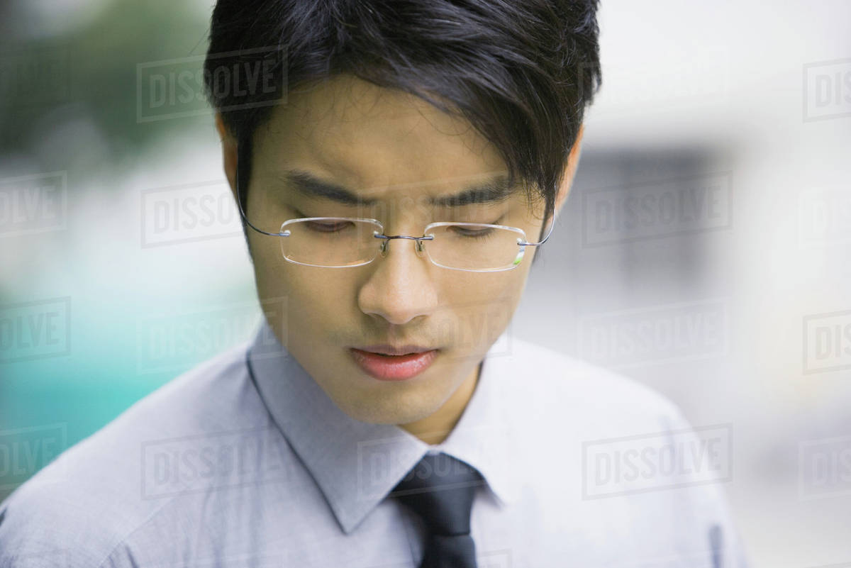 Businessman looking down, closeup, portrait Stock Photo Dissolve