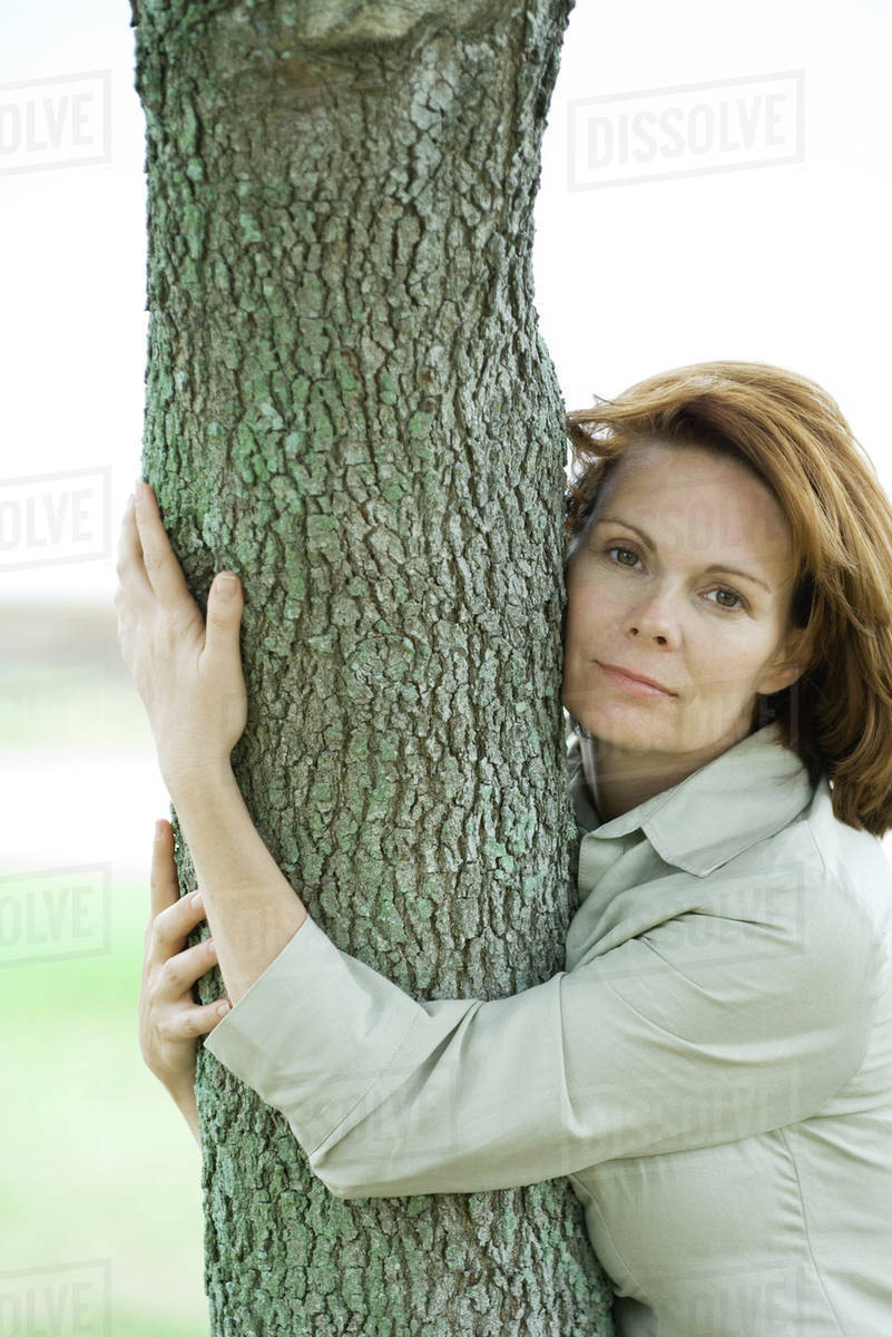 Woman hugging tree trunk, portrait - Royalty-free Stock Photo | Dissolve