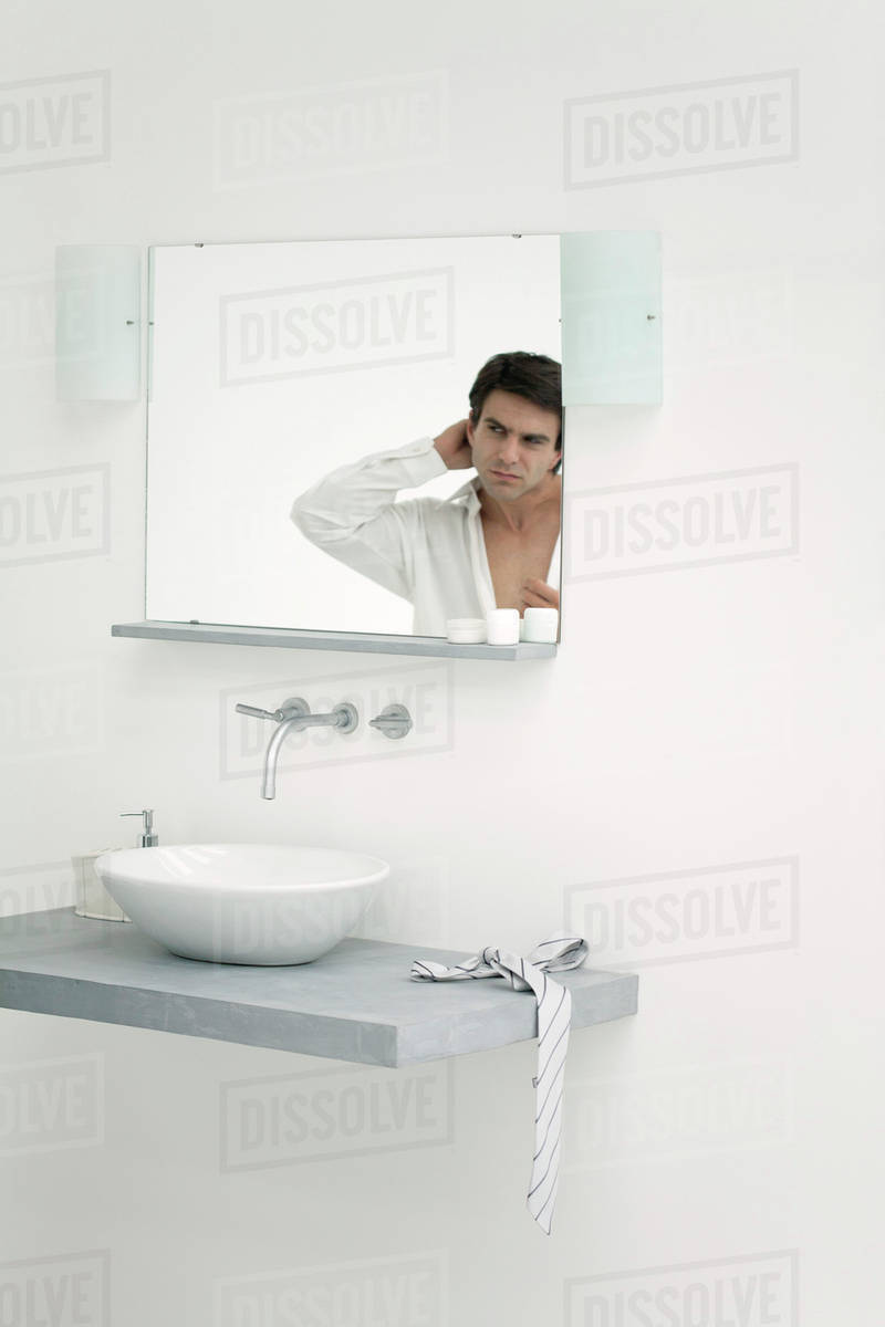 Man Looking At Self In Bathroom Mirror Stock Photo Dissolve Man Looking At Self In Bathroom Mirror
