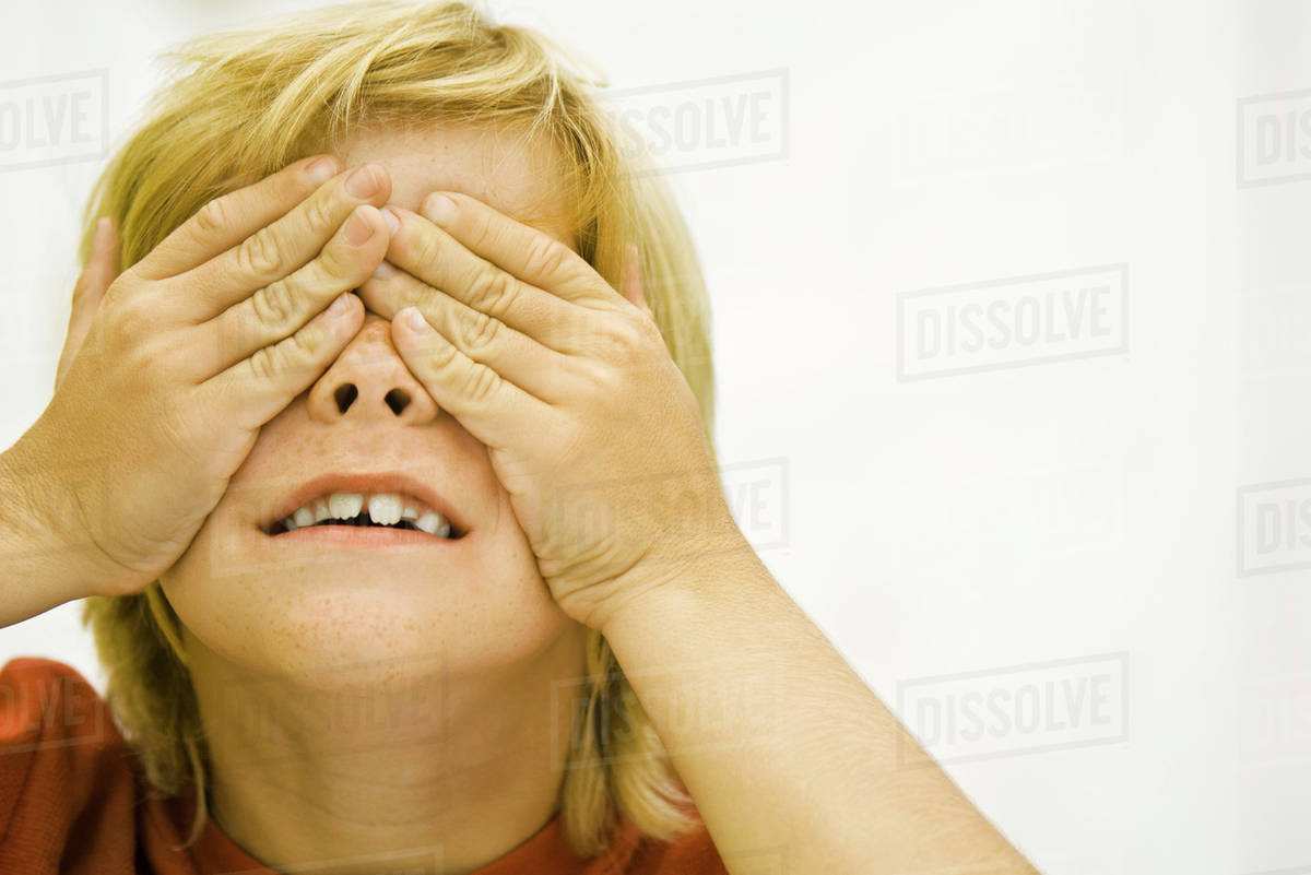Boy covering eyes with hands Stock Photo Dissolve