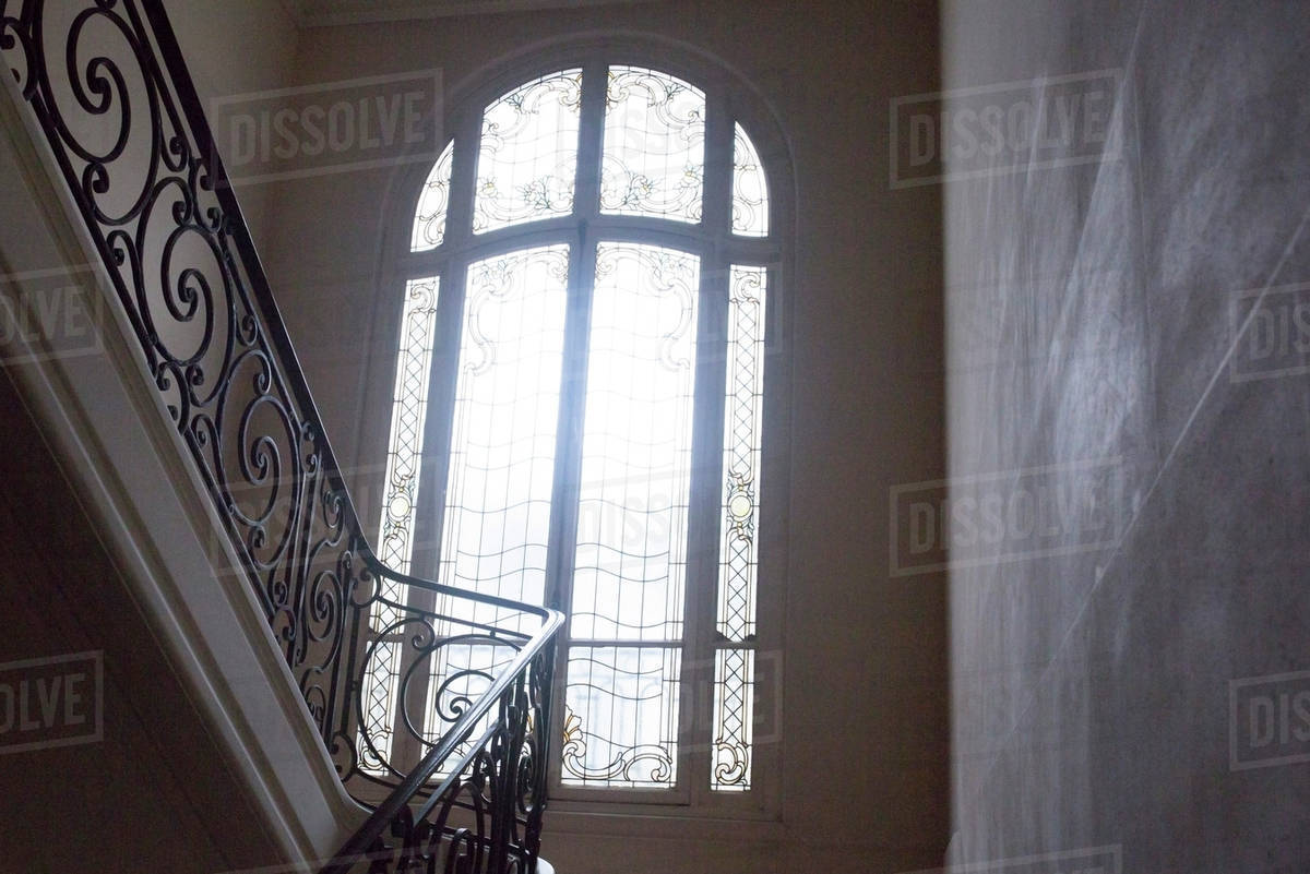 Arched window at top of stairs - Stock Photo - Dissolve