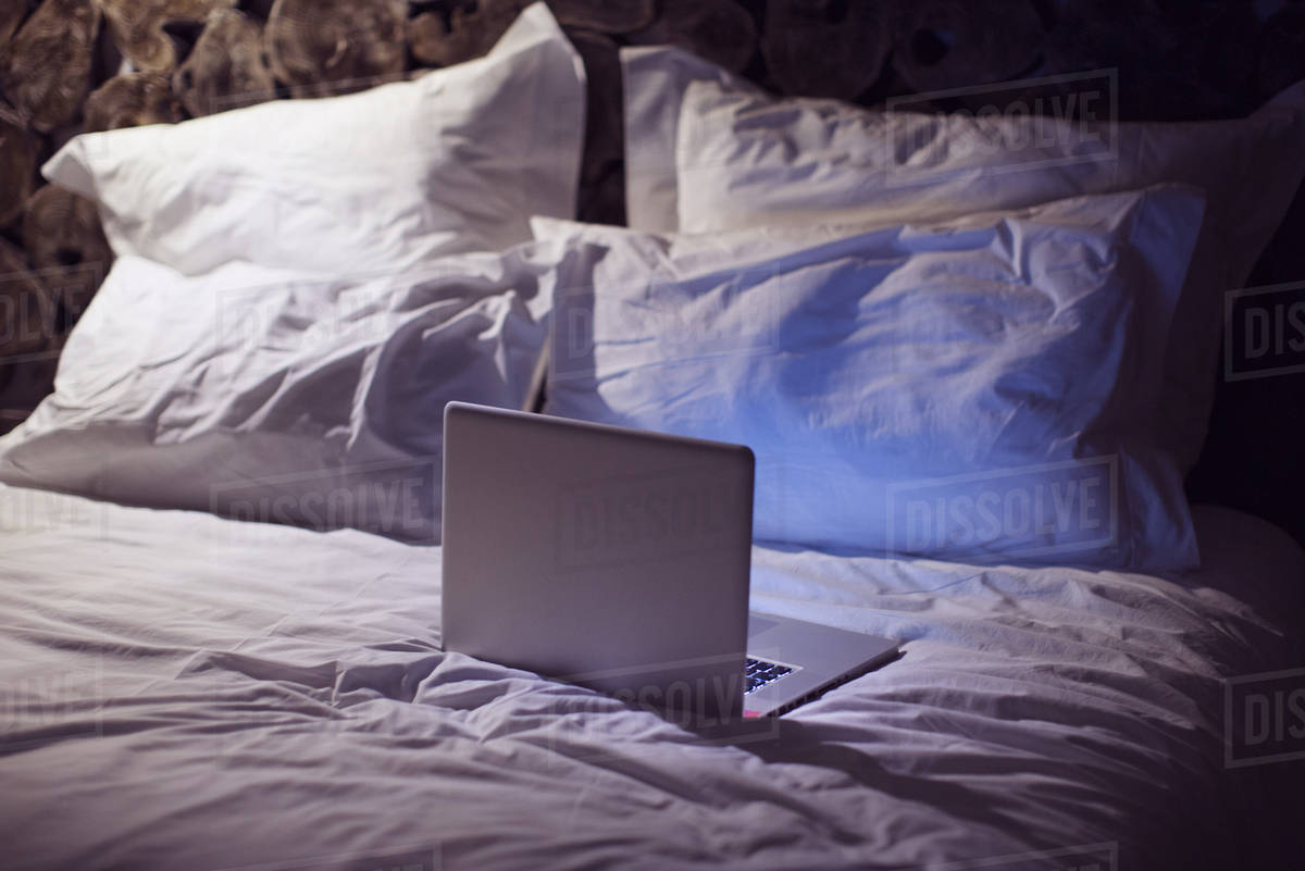 Laptop computer on bed Stock Photo Dissolve