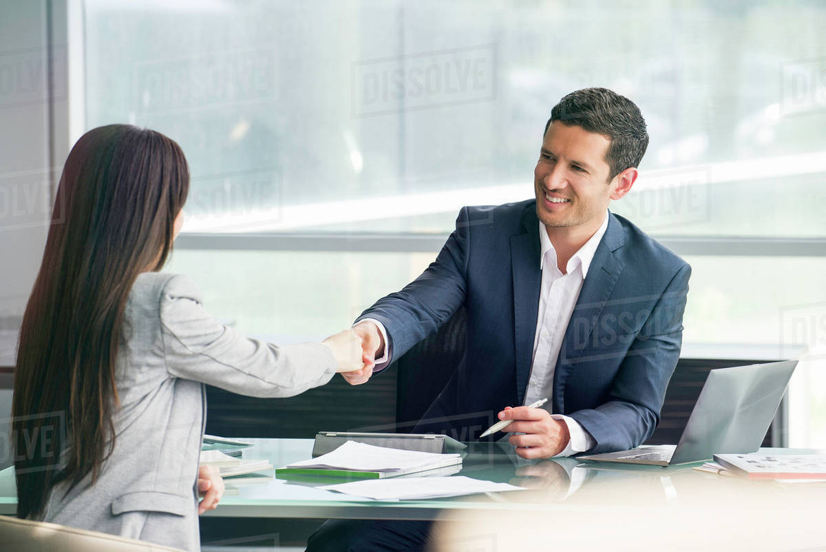 Businessman shaking hands with client Stock Photo Dissolve