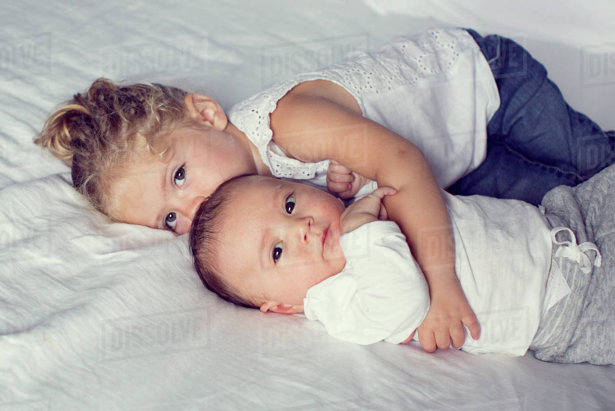 Little girl cuddling with baby brother Stock Photo Dissolve