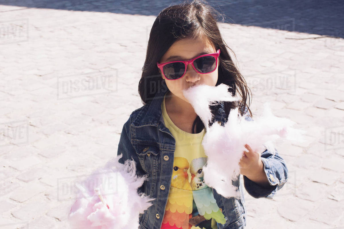 Little girl eating cotton candy Stock Photo Dissolve