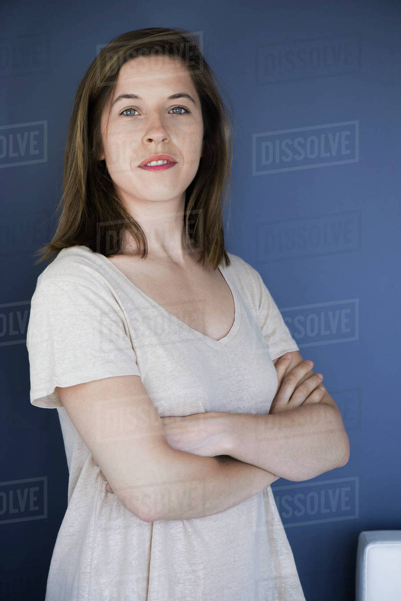 Woman with arms folded across chest, portrait Stock Photo Dissolve