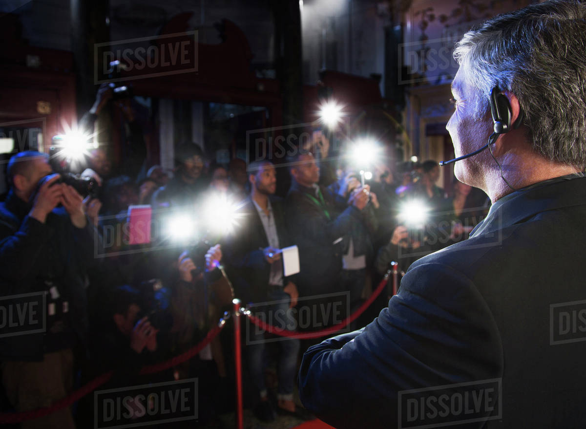 Bodyguard watching paparazzi at red carpet event Stock Photo Dissolve