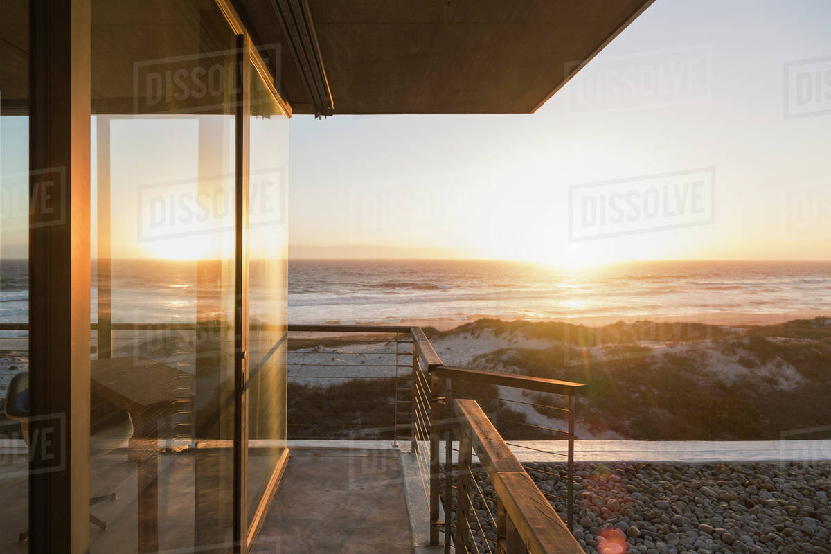 View of sunset over ocean from balcony of modern house Stock Photo
