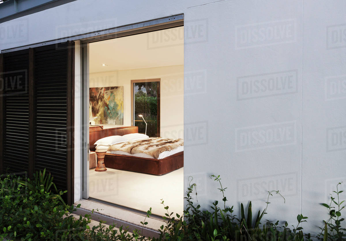 Sliding door open to modern bedroom Stock Photo Dissolve
