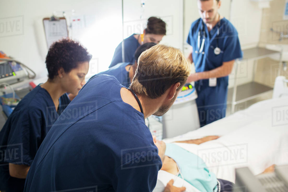 Team of doctors attending patient in hospital Stock Photo Dissolve