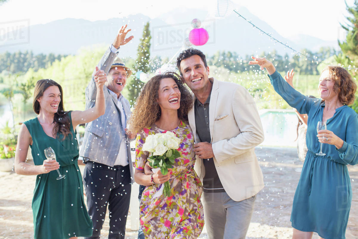 Family throwing rice on newlywed couple - Royalty-free Stock Photo ...