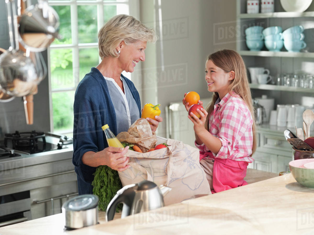 Woman and granddaughter unloading groceries Stock Photo Dissolve
