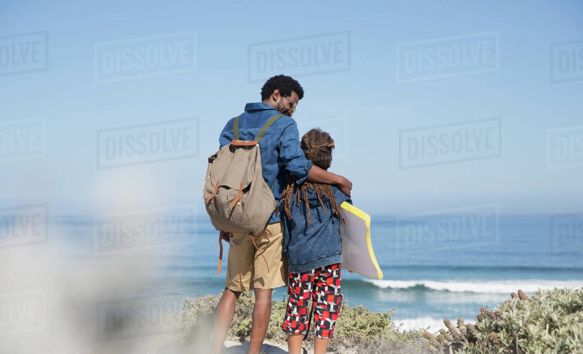 Father And Son Walking With Boogie Board On Sunny Summer Ocean Beach Father And Son Walking With Boogie Board On Sunny Summer Ocean Beach