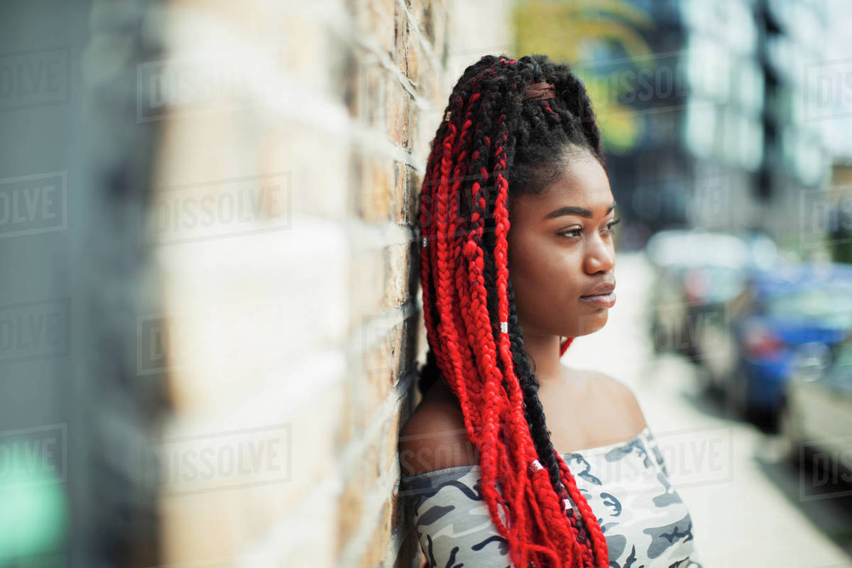 Confident young woman with red braids looking away on urban D985_70_152