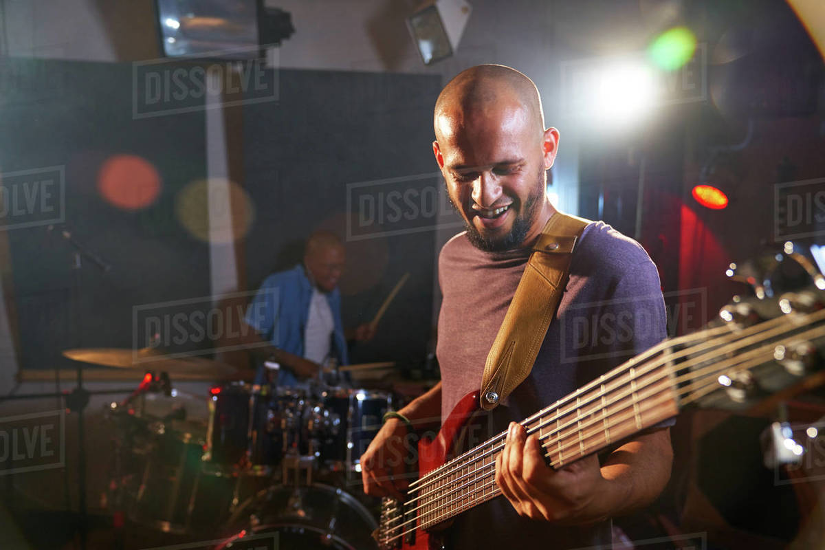 Male guitarist and drummer performing on stage Stock Photo Dissolve