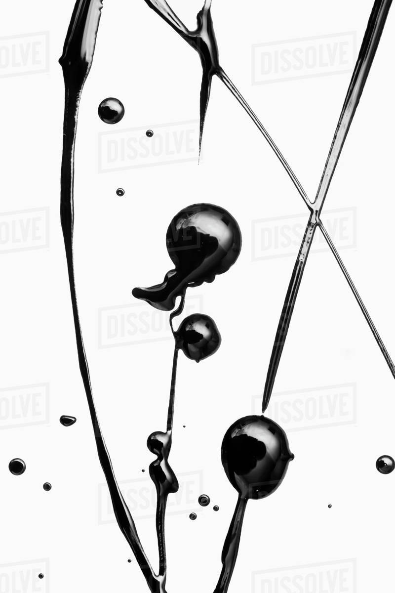 Black paint splattered on a white surface making an elegant pattern