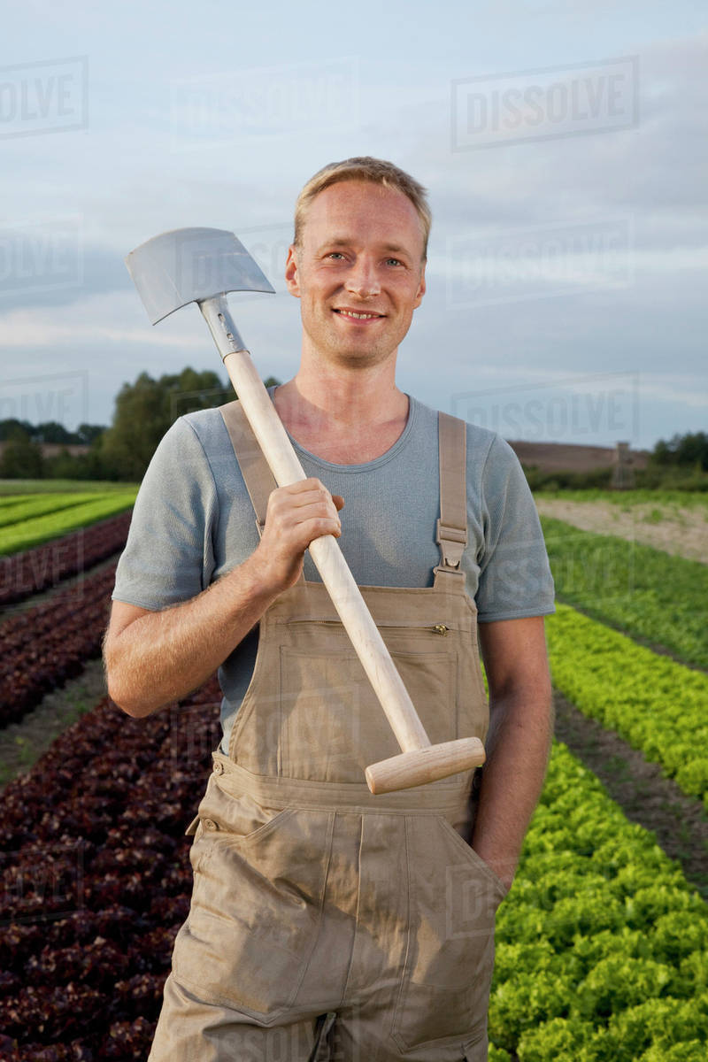 A man carrying a shovel on his shoulder Stock Photo Dissolve