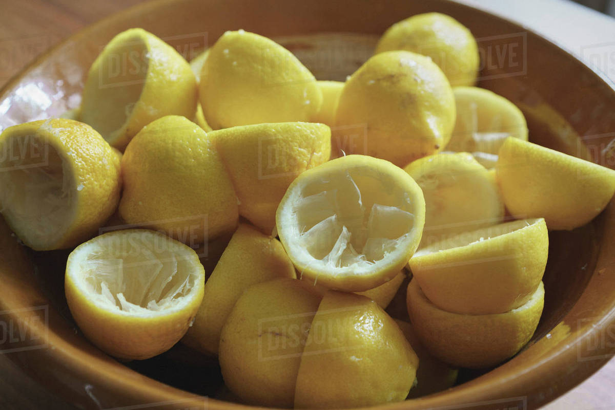 Closeup of juiced lemon halves on plate Stock Photo Dissolve