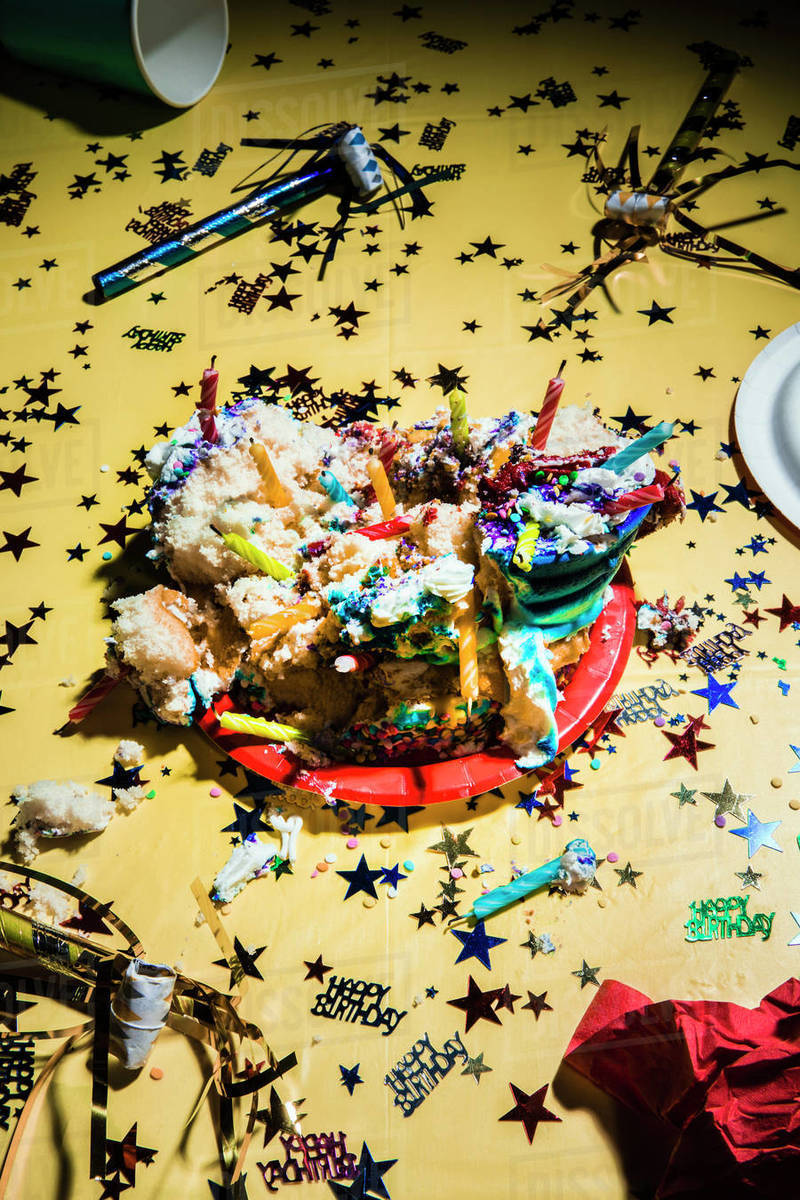 Messy birthday cake and confetti on yellow background - Stock Photo ...