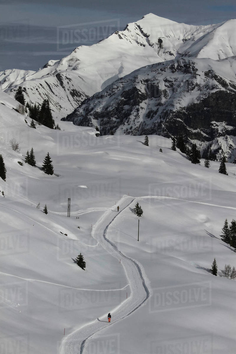 Snowshoers on sunny, snowy mountain path, Vals, Canton of Grisons, Switzerland Royalty-free stock photo