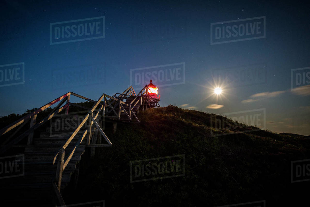 Illuminated lighthouse under full moon night sky, Norddorf, Schleswig Holstein, Germany Royalty-free stock photo