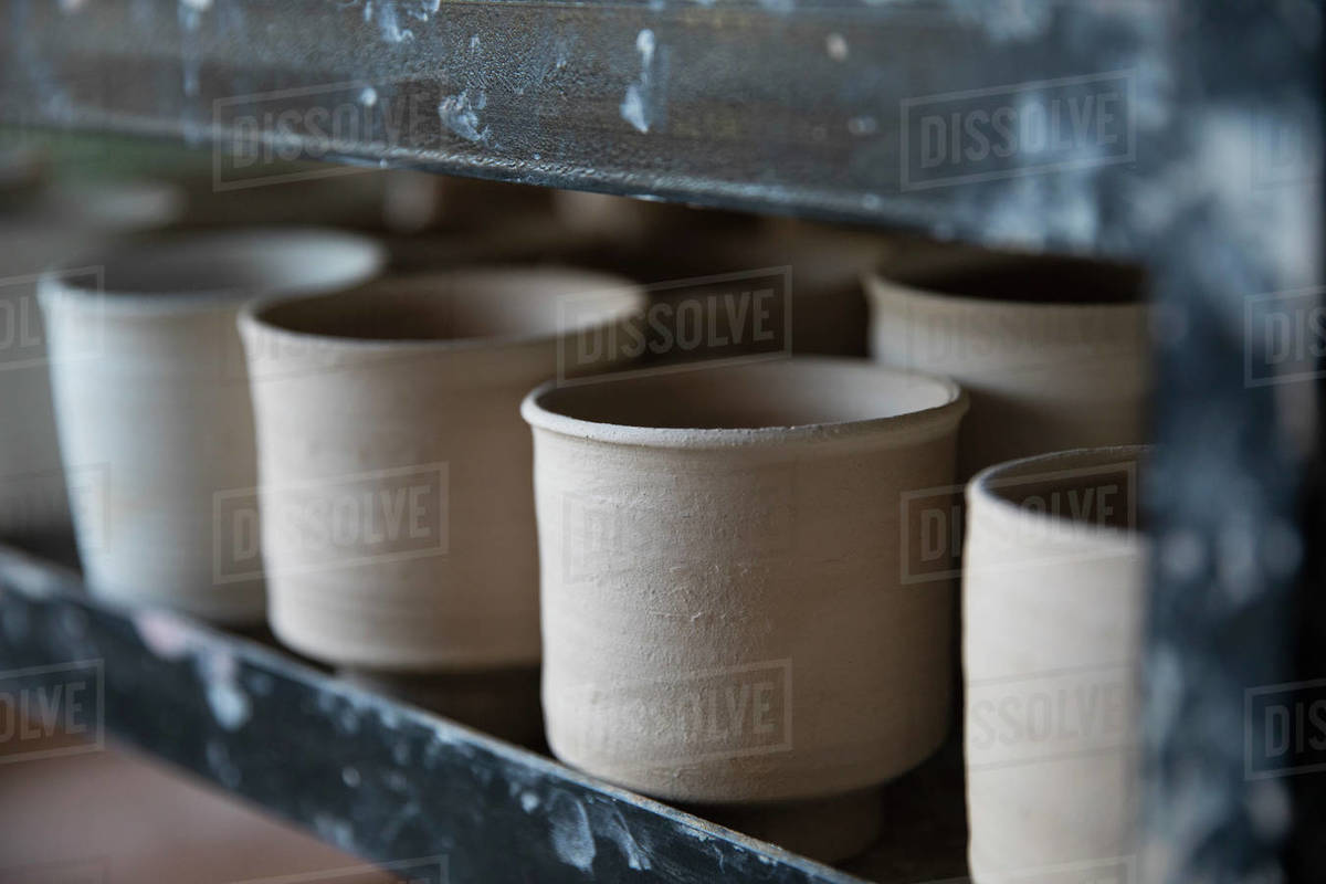 Thrown clay cups drying in a row Stock Photo Dissolve